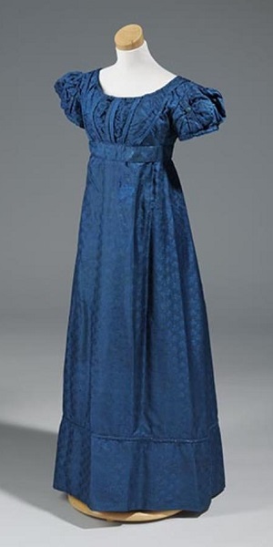 1824 Woman's royal blue brocade; empire waist; round neck; puffs at top of sleeves; belted at waist; center back opening. A separate pair of long sleeves (A-B) are also in royal blue brocade. North Carolina Museum of History
