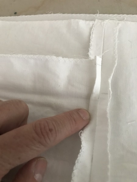 Fold or iron the the top of the seam twice to make a narrow hem